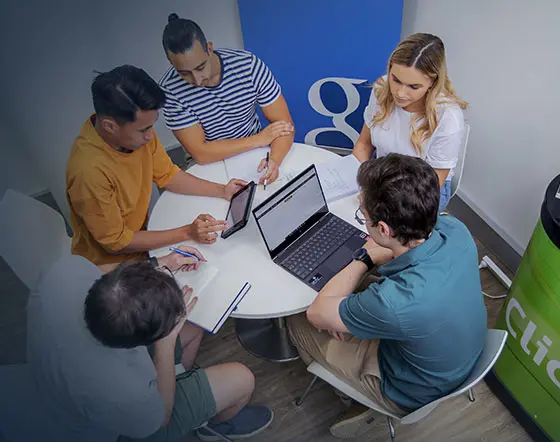 Click Click Media team hard at work around a table mobile image version